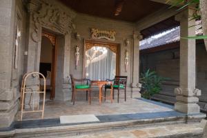 a patio with chairs and a table on a house at Bungalow Geringsing in Candidasa