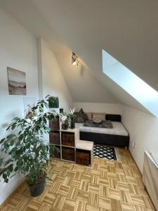 a attic bedroom with a bed and a potted plant at BullsLiving Seeapartment 5 in Velden am Wörthersee