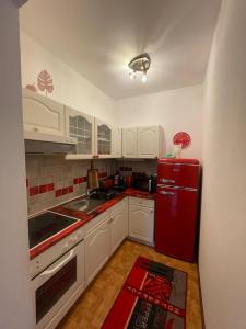 a kitchen with a red refrigerator and white cabinets at BullsLiving Seeapartment 5 in Velden am Wörthersee