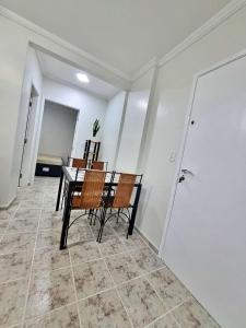 comedor con mesa y sillas en 01 dorm c/ar cond, wi-fi, 1 vaga, praia da Enseada, próx ao Pão de Açúcar en Guarujá