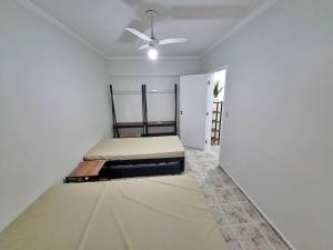 1 dormitorio con 2 camas y ventilador de techo en 01 dorm c/ar cond, wi-fi, 1 vaga, praia da Enseada, próx ao Pão de Açúcar en Guarujá
