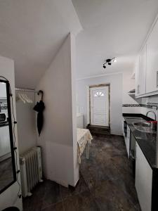 a kitchen with white walls and a table and a door at Casa Cor de Rosa in Lisbon