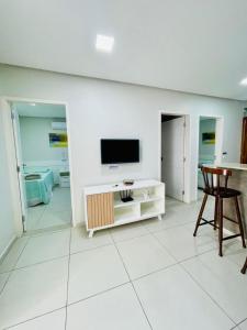 ein Wohnzimmer mit einem TV an einer weißen Wand in der Unterkunft Flats Manoel Tavares 102 in Garanhuns