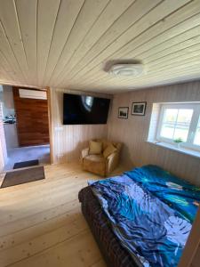ein Schlafzimmer mit einem Bett und einem Stuhl in einem Zimmer in der Unterkunft Joosti Summer House in Käsmu