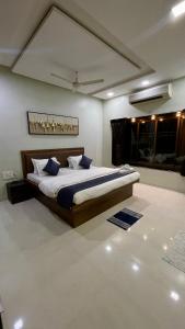 a bedroom with a large bed with blue pillows at VARDHAN CORPORATE STAY in Pune
