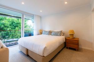 1 dormitorio con cama y ventana grande en Riverside studio apartment with parking and view en Brisbane