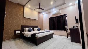 a bedroom with a bed and a ceiling fan at VARDHAN CORPORATE STAY in Pune