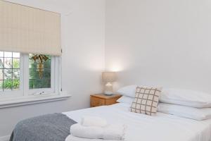Habitación blanca con cama y ventana en Western Wonder - Free wine, en West Richmond