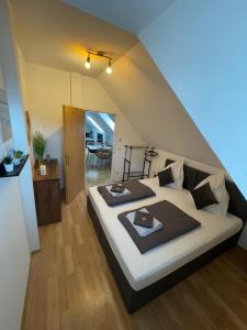 a bedroom with a bed with two plates on it at BullsLiving Seeapartment 5 in Velden am Wörthersee