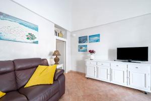 a living room with a couch and a flat screen tv at Vico di Ostuni Stone Houses in the Heart of Ostuni by Rentbeat in Ostuni