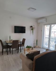 a living room with a table and a tv on the wall at Sunčani apartman 1 in Krupanj