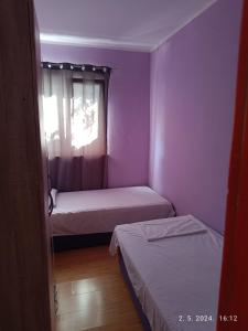 een kleine kamer met 2 bedden en een raam bij Leonica in Omiš