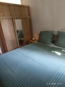 een slaapkamer met een bed met een blauw dekbed en een spiegel bij Leonica in Omiš