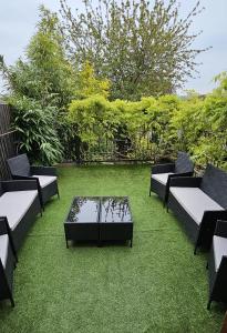 a group of chairs and a table on the grass at The Hive 4 Bed House Pool Table Air-con in Maidstone