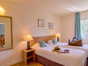a hotel room with two beds and a mirror at Apartment Reine Marine- T2 SUD by Interhome in Saint Malo