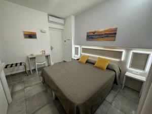 sypialnia z łóżkiem z 2 żółtymi poduszkami w obiekcie B&B Holiday Tropea w Tropei
