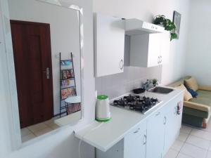 una cucina bianca con fornelli e lavello di Przytulne Mieszkanko Centrum a Mrągowo Altre 2 foto