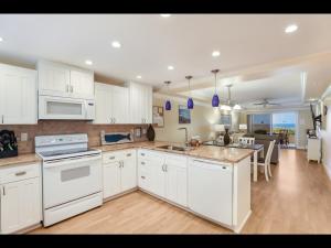 a kitchen with white appliances and a dining room at 4200 GULF DRIVE UNIT 108 home in Holmes Beach