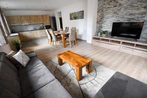 a living room with a couch and a table at Wellness Villa Bobrik in Pribylina