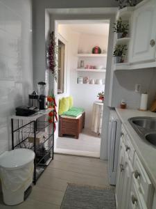 a kitchen with a sink and a door leading into a room at Cantinho do Céu in Alcácer do Sal