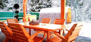 una mesa de madera y sillas en un patio en Wellness Villa Bobrik en Pribylina