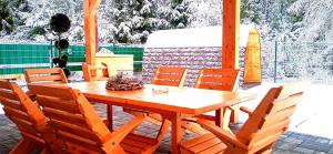 a wooden table and chairs on a patio at Wellness Villa Bobrik in Pribylina +51 photos