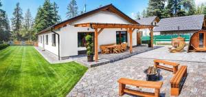 una casa con un pabellón con bancos en un patio en Wellness Villa Bobrik en Pribylina