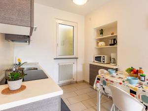 a kitchen with a counter and a table with chairs at Apartment Raggio di Sole Apartment A by Interhome in Consiglio di Rumo