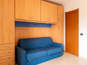 a blue couch in a room with wooden cabinets at Apartment Raggio di Sole Apartment A by Interhome in Consiglio di Rumo
