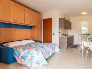 a bedroom with a bed and a kitchen with a table at Apartment Raggio di Sole Apartment A by Interhome in Consiglio di Rumo