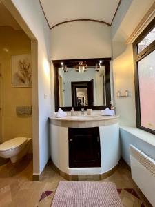 bagno con lavandino, servizi igienici e specchio di Villa Sofia - Golf Amelkis Marrakech a Marrakech