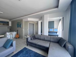 een woonkamer met een grijze bank en een blauw tapijt bij Love of Bodrum House in Bodrum City