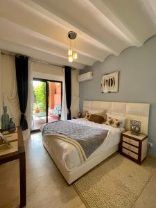 - une chambre avec un grand lit blanc et une fenêtre dans l'établissement Villa Sofia - Golf Amelkis Marrakech, à Marrakech