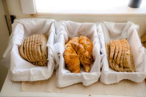 three baskets filled with cookies and croissants on a counter at Green Coast Surf House in Espinho