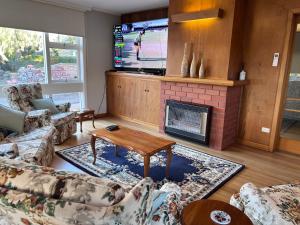 サンディ・ベイにあるMagnolia Houseの暖炉とテレビのあるリビングルーム