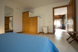 a bedroom with a blue bed and a hallway at Casa Gianfranco - ACrapa Mangia in Santa Maria di Castellabate