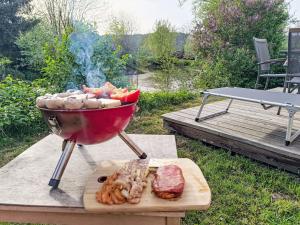 a barbecue grill with meat and vegetables on a table at Holiday Home Tiny Haus Sonnendeck by Interhome in Beilngries