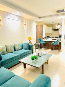 a living room with a blue couch and a table at Mirhaa Homes # 1 -Gold Crest Mall One Bed Apartment By Dr - Subhan Shahid in Lahore