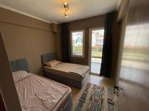 two beds in a room with a window at Merkezde denize 5 dakika villa in Kusadası
