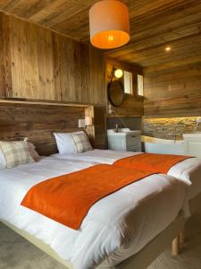 Cama grande en habitación con paredes de madera en Hotel des Pyrénées en Font Romeu