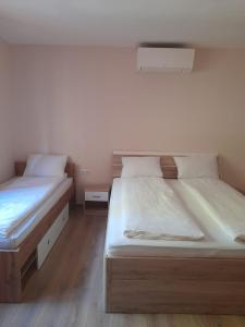 Casa Veveritelor : سريرين في غرفة صغيرة مع أرضيات خشبية