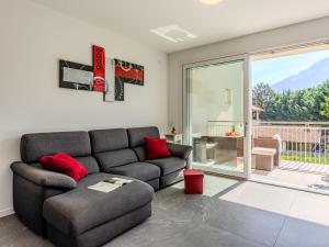 a living room with a couch and a sliding glass door at Apartment Sunny House by Interhome in Gravedona