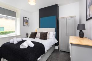 um quarto com uma cama em preto e branco e uma secretária em Fabulous 3 bed house in Burnley em Brierfield