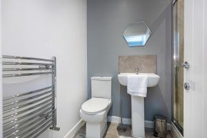 La salle de bains est pourvue de toilettes blanches et d'un lavabo. dans l'établissement Fabulous 3 bed house in Burnley, à Brierfield