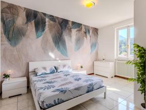 1 dormitorio con cama y pared con plumas en Apartment Leo by Interhome, en Lenno