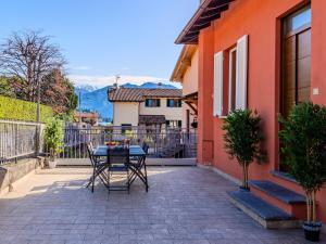 Un patio con una mesa y sillas frente a una casa. en Apartment Leo by Interhome, en Lenno