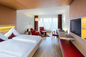 a hotel room with a bed and a flat screen tv at Hotel Traube am See in Friedrichshafen