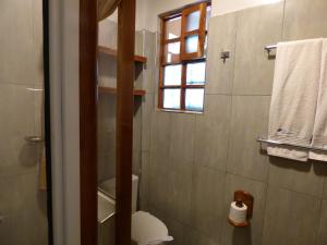 a bathroom with a toilet and a window at Le Pristine Wellness and Healing Hotel in Nyeri