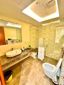 a bathroom with a sink and a toilet and a shower at Mirhaa Homes # 1 -Gold Crest Mall One Bed Apartment By Dr - Subhan Shahid in Lahore