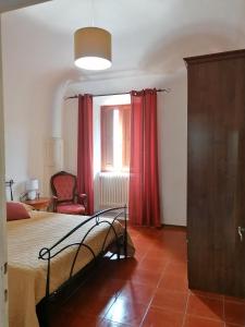 a bedroom with a bed and a red curtain at appartamento Casa Mosaico in Volterra